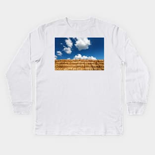 Bales of straw under blue cloudy sky Kids Long Sleeve T-Shirt